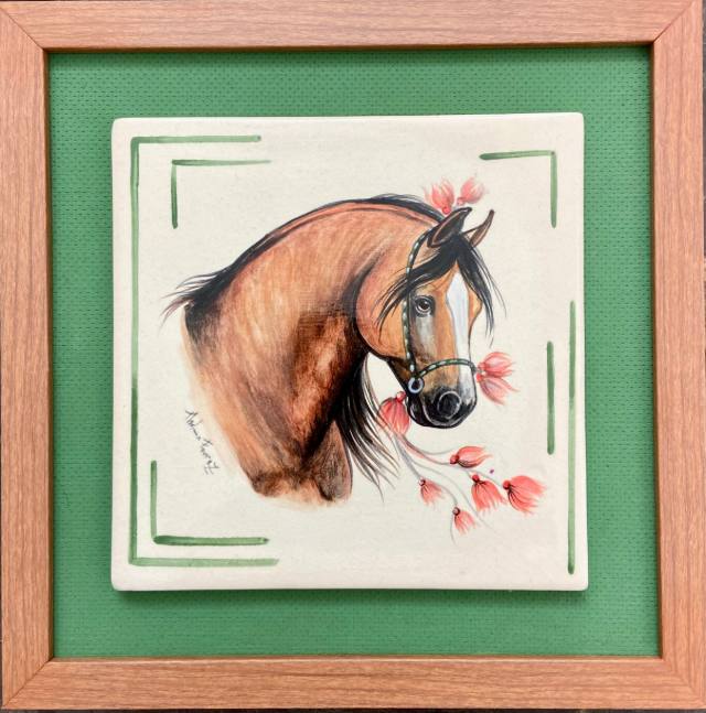 Azulejo de cerâmica com cavalo baio e flores cor-de-rosa, emoldurado em madeira com fundo verde