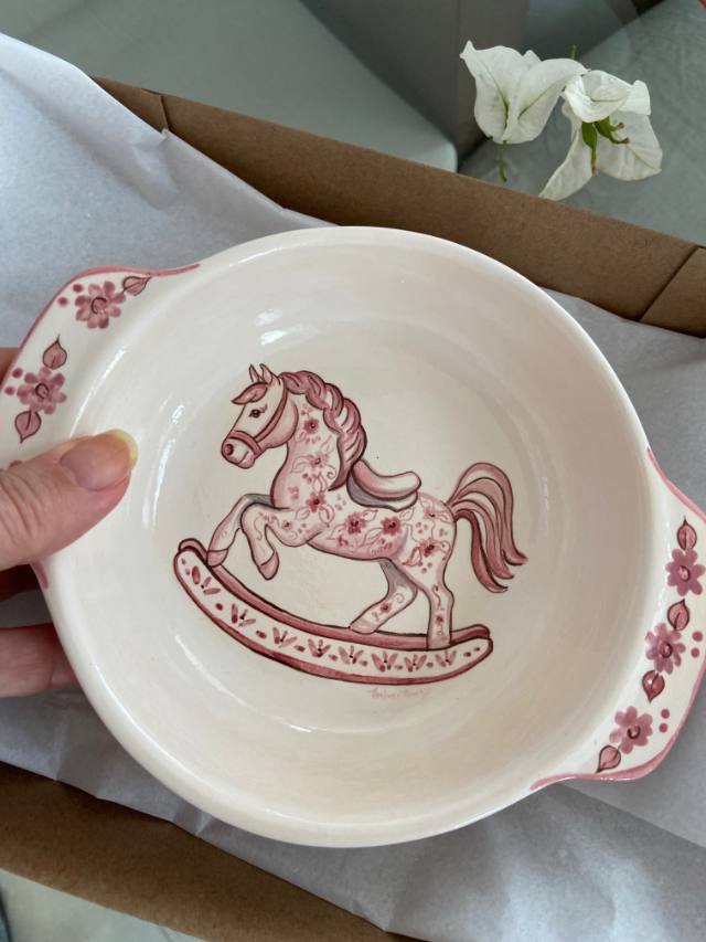 Bowl de cerâmica com cavalinho de balanço cor-de-rosa em uma caixa de presente
