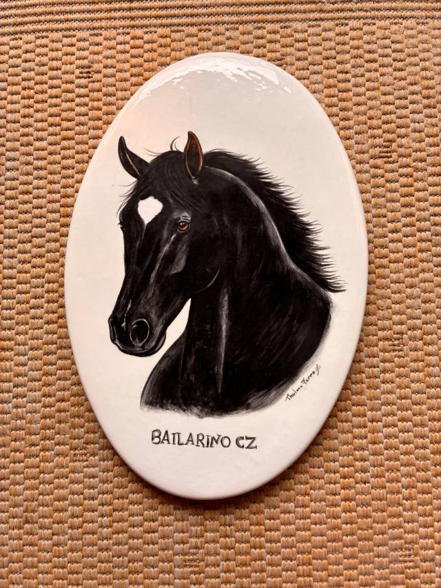Placa oval de cerâmica com retrato de cavalo preto e o nome do animal pintados à mão