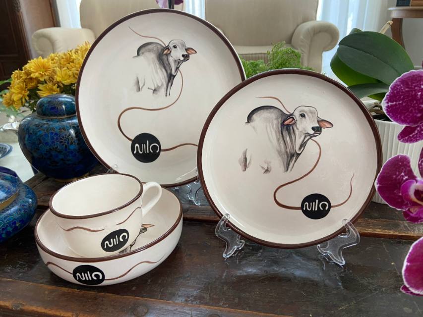 Pratos, xícara e bowl de cerâmica com boi Nelore e a marca do cliente pintados à mão