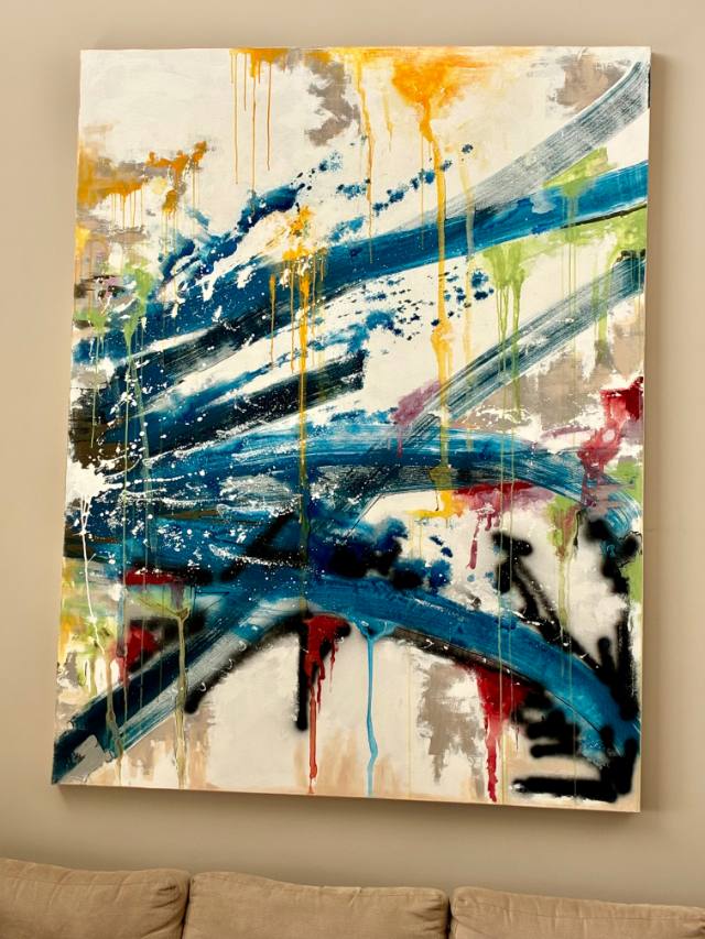 Tela abstrata em azul pendurada na parede, sobre um sofá