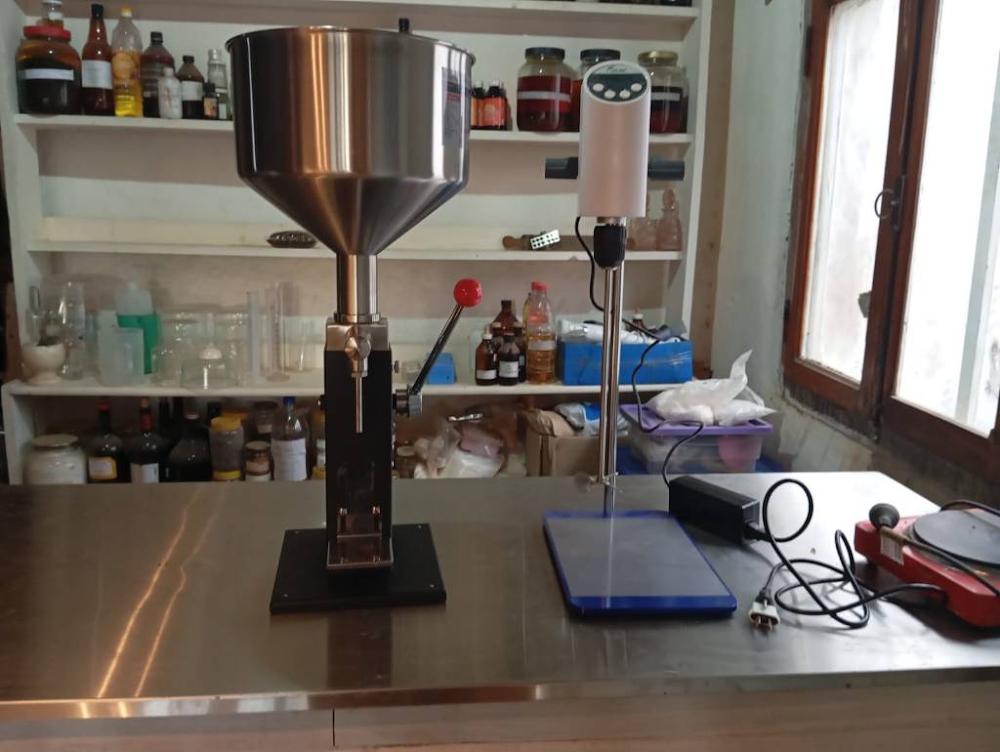 Instrumentos de laboratorio, estanter&iacute;as con fitoextractos y envasadora de acero inoxidable en el espacio de producci&oacute;n de Alma de Hornero.