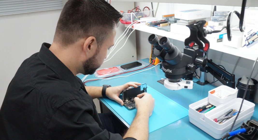 T&eacute;cnico da Playfix realizando reparo em celular