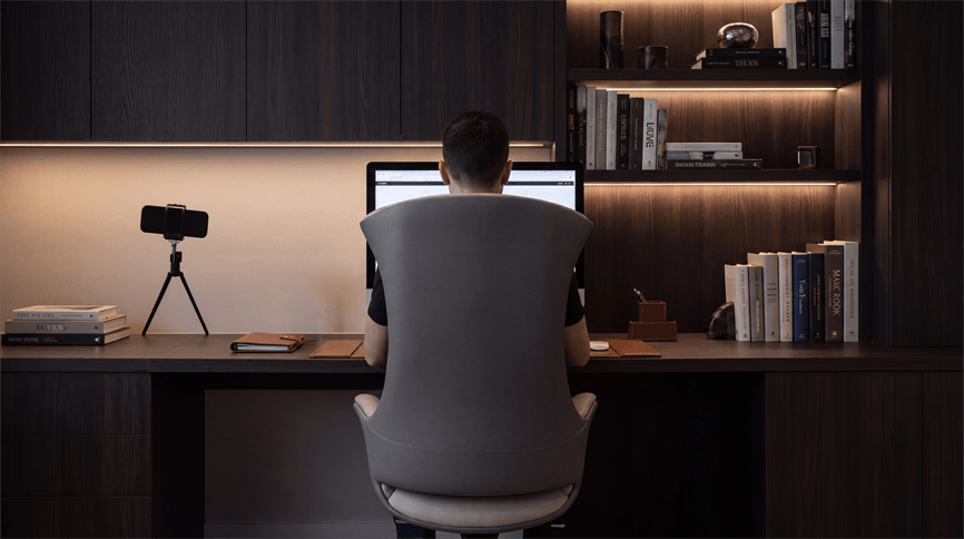 Cadeira Shark diante de mesa com monitor e estante em ambiente de trabalho