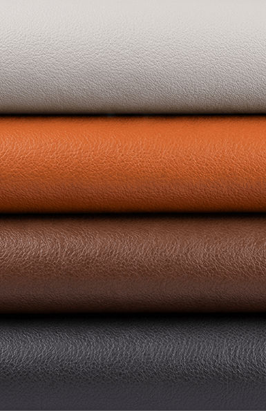 Amostras empilhadas do revestimento Eco Nappa da cadeira Valen nas cores off-white, laranja, marrom e grafite