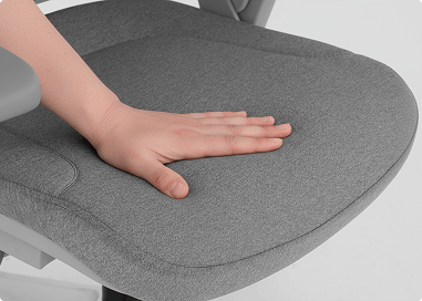 Imagem ampliada do assento com uma mão passando suavemente demonstrando todo o conforto da tecnologia Memory Foam.