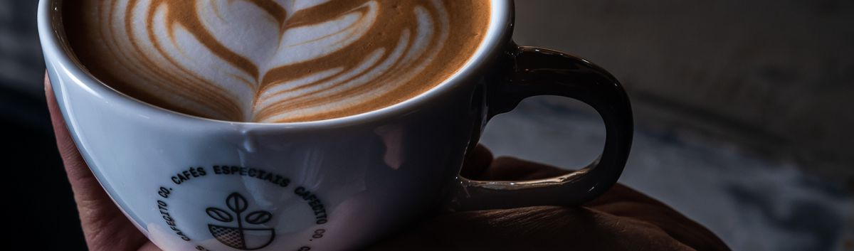 Xícara de cappuccino com desenho de folha na espuma