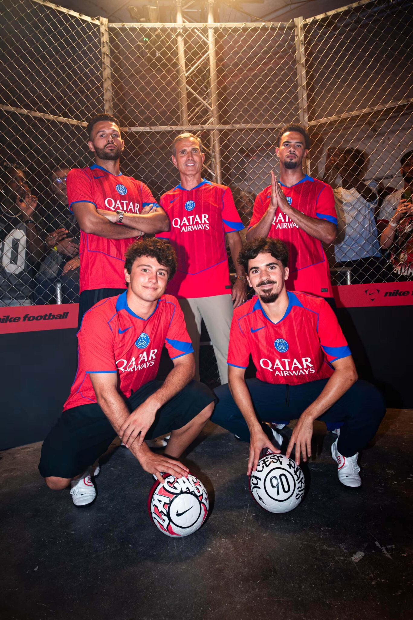 Jogadores do PSG vestindo a terceira camisa Total 90 2025/26 vermelha com gola V azul e punhos detalhados