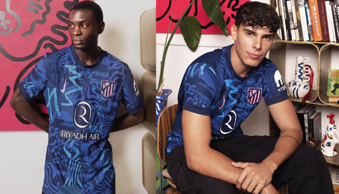 Terceira Camisa do Atl&eacute;tico de Madrid 2024/2025: azul marinho com grafismo vibrante. Destaques incluem o tridente de Netuno, Nike Swoosh rosa e escudo do Atleti em azul e rosa.