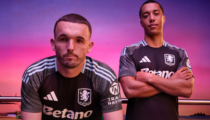 Camisa reserva Aston Villa Adidas 25/26 com design minimalista em tons de carvão, detalhes cinza e escudo monocromático, inspirada na arquitetura de Birmingham.