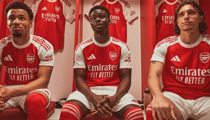 Camisa titular do Arsenal Adidas 2025/26 nas cores vermelha e branca, com escudo monocromático e detalhes em padrão gótico inspirado no escudo antigo do clube.