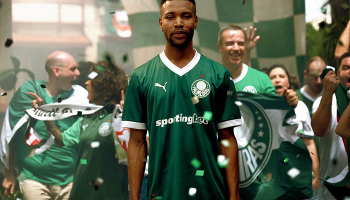 Camisa titular do Palmeiras 2025 na cor verde com gola V branca em estilo retrô. Estampa exclusiva com referência às taças conquistadas pelo Verdão, 12 estrelas representando os títulos brasileiros e releitura da bandeira do Brasil.