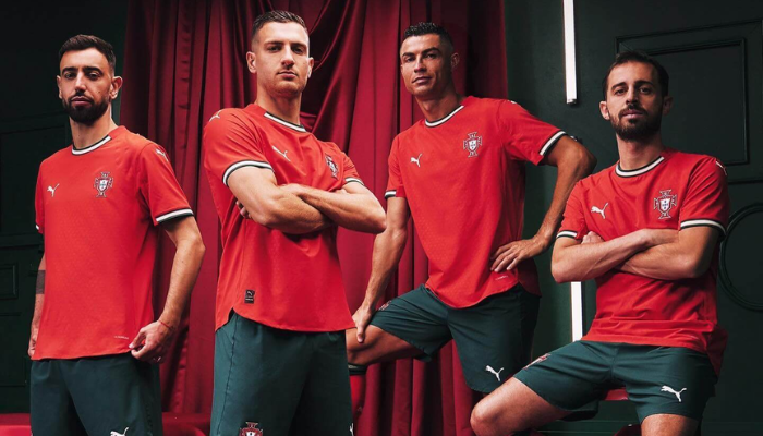 Camisa da Sele&ccedil;&atilde;o Portuguesa 2025/26, fabricada pela Puma. Predominantemente vermelha, com detalhes em verde e branco, traz um design que homenageia os cinco besantes do bras&atilde;o portugu&ecirc;s. Inclui escudo da sele&ccedil;&atilde;o, logo da Puma e detalhes hist&oacute;ricos, como a quina no interior da gola.