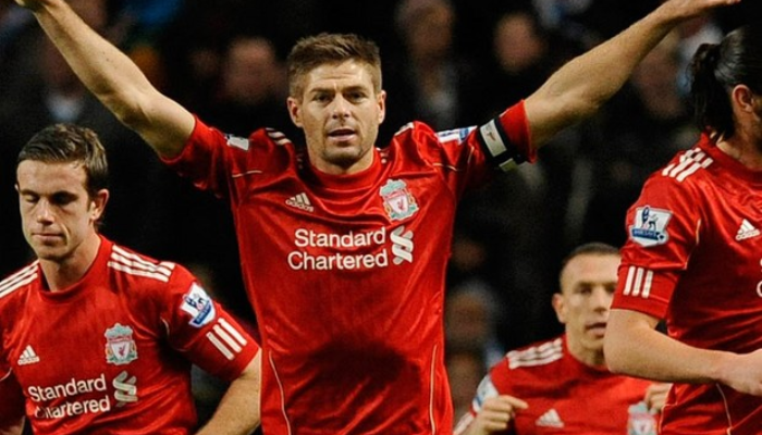 Camisa Retro Titular do Liverpool 2010-2012 em vermelho e branco. Camisa oficial usada durante a temporada turbulenta ap&oacute;s a sa&iacute;da de Rafa Ben&iacute;tez e a chegada de Roy Hodgson. A equipe se recuperou com a volta de Kenny Dalglish e a contrata&ccedil;&atilde;o de Luis Su&aacute;rez, conquistando a Copa da Liga.