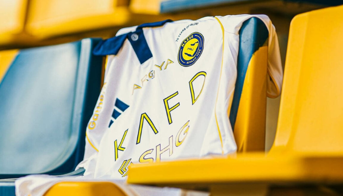 Camisa terceira do Al-Nassr Adidas 2025/2026 branca, com gola polo azul, detalhes amarelos e textura em embossing no tecido, modelo versão jogador.