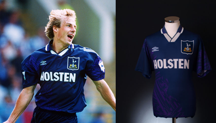 Camisa de futebol retr&ocirc; do Tottenham Hotspur da temporada 1994-1995, modelo utilizado por J&uuml;rgen Klinsmann em sua estreia pelo clube. A camisa apresenta as cores azul marinho, roxo e branco, com o logo da Umbro e o escudo do Tottenham.