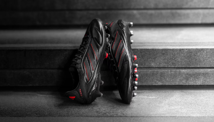 Imagem da Chuteira Adidas Copa Pure 3 FG, destacando seu design em preto e vermelho, material Fusionskin e a Comfortframe soleplate para máxima performance.