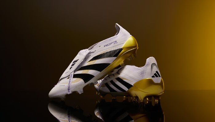 Chuteira Adidas Predator 24 FG Road to Glory branca com detalhes dourados, preta e roxa, com língua dobrável e solado para campo firme.