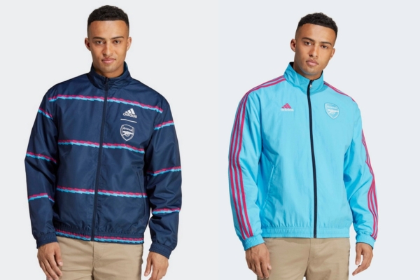 Jaqueta Hino Revers&iacute;vel Arsenal Adidas 2022-2023 em azul marinho com raios horizontais, e do outro lado em azul 'Sky Rush' mais claro com detalhes em magenta na marca, destacando o design rel&acirc;mpago.
