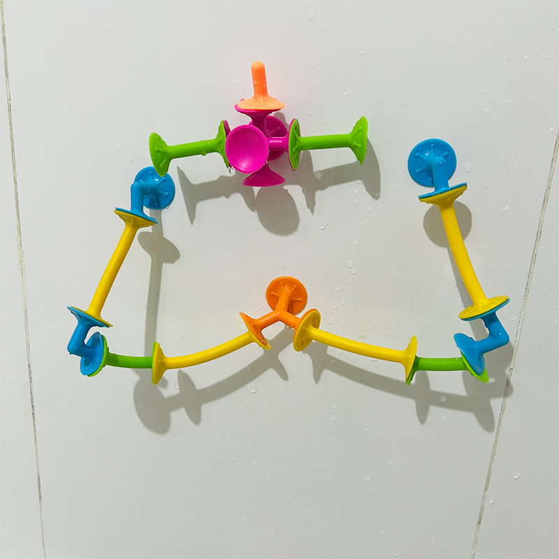 Sopapas PopFun unidas en fila y pegadas en los azulejos del baño
