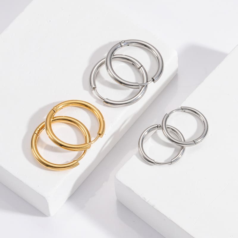 mixed-steel-and-gold-hoop-earrings-on-ornate-mirror