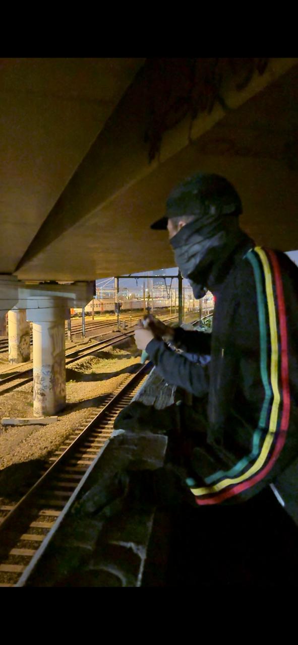 Artista de graffiti Prosa observando o spot de trens na Bélgica durante a noite.