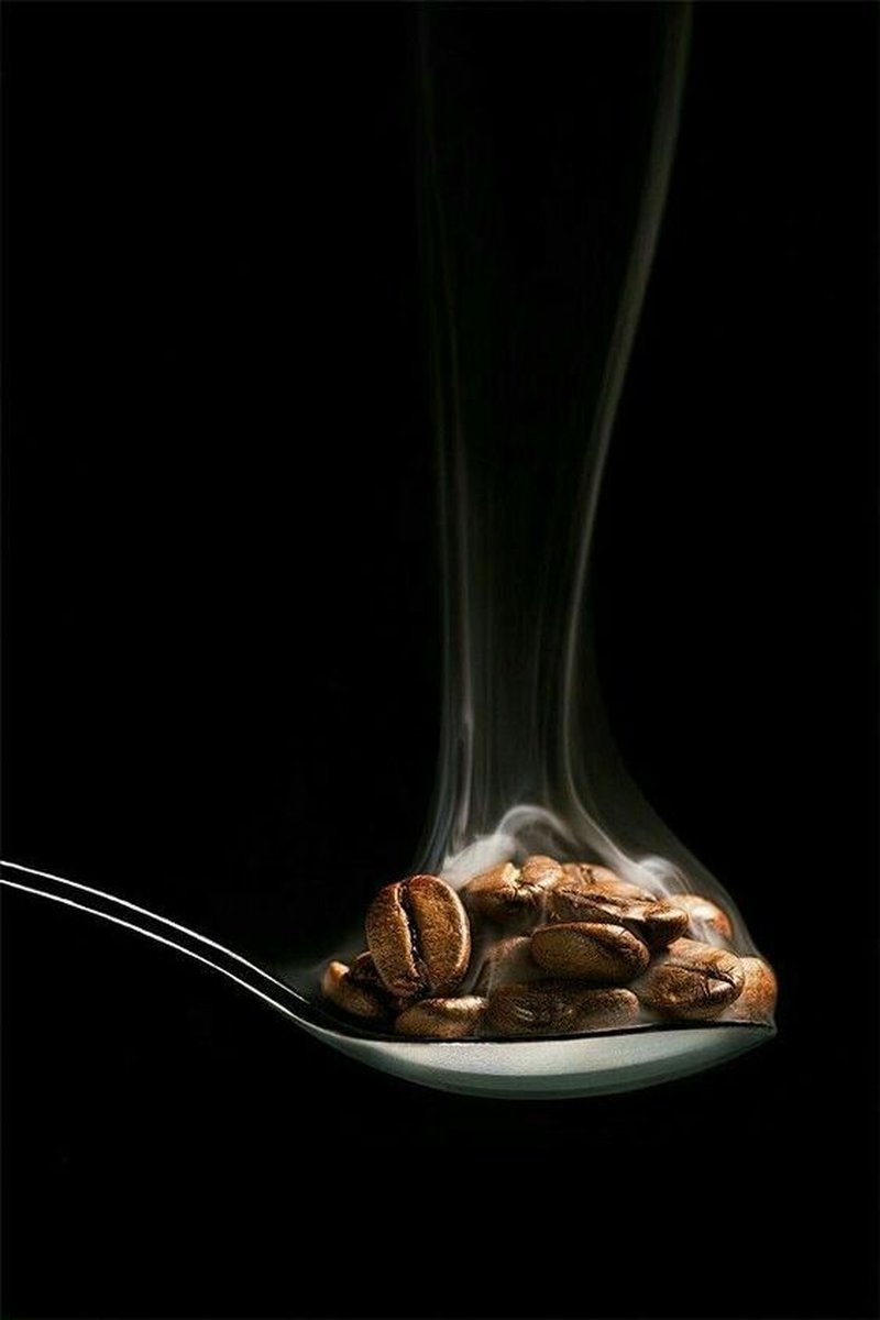Grãos de café fumegantes em uma colher
