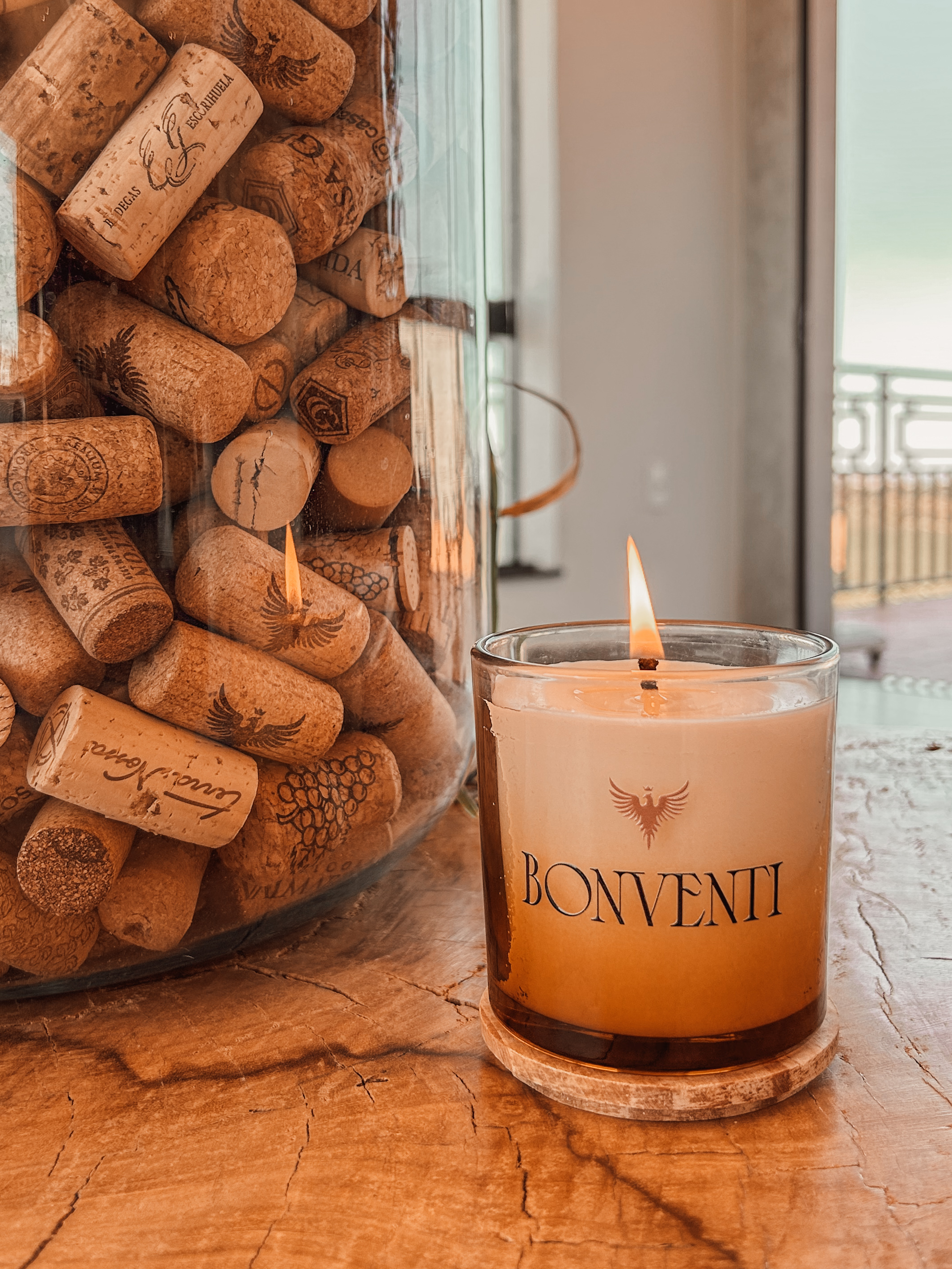 Vela aromática personalizada Bonventi ao lado de rolhas de vinho