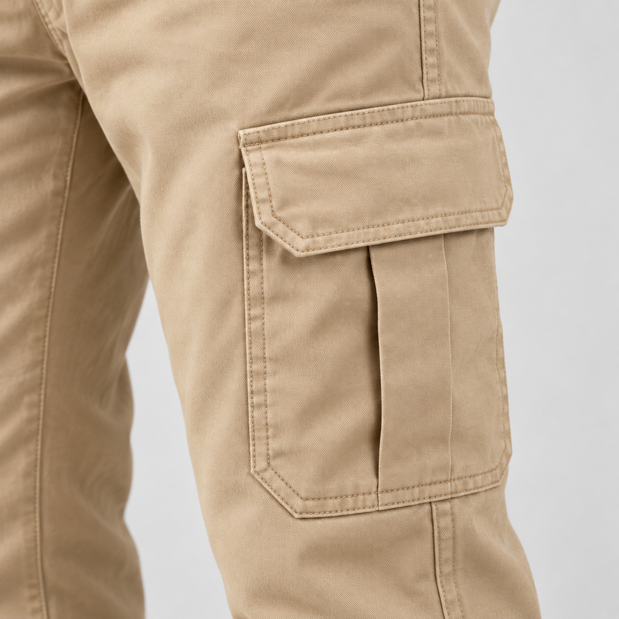 Bolso cargo lateral com aba e prega central em sarja bege.