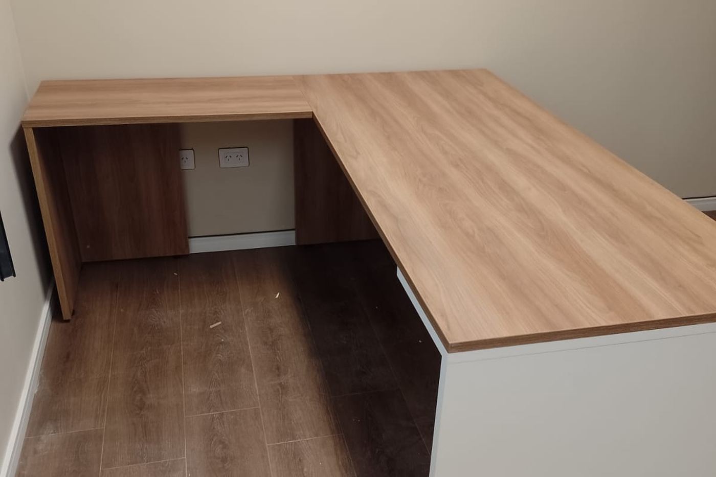 Escritorio en L de melamina símil madera con cajonera, en oficina dentro de una planta