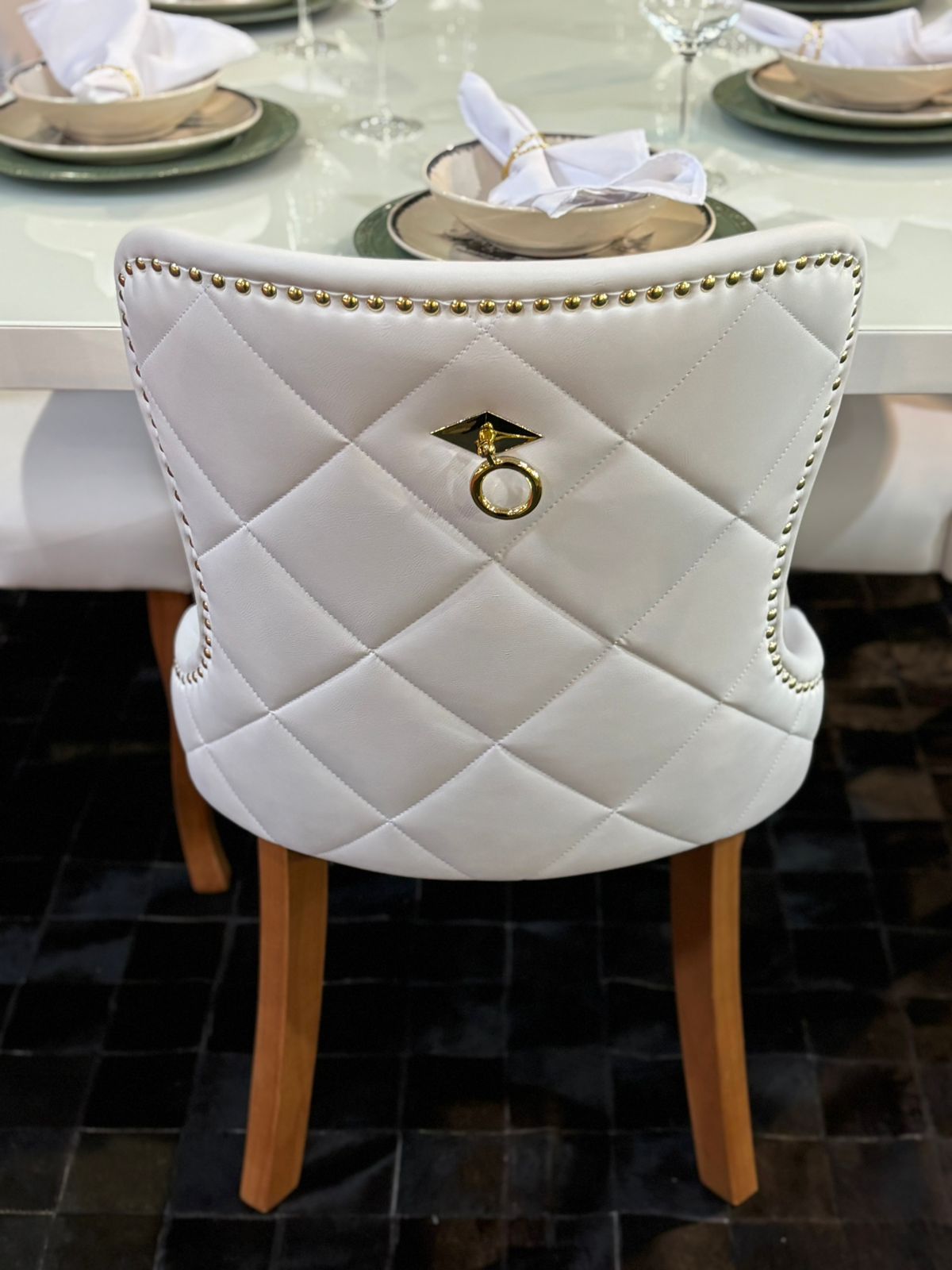 Detalhe lateral da Cadeira Cristal com costura em losangos, tachas e puxador dourado
