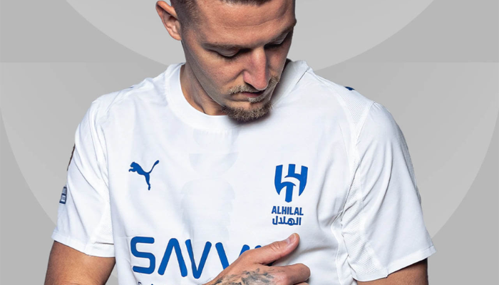 Camisa reserva Al-Hilal Puma 2025-2026 branca com faixa vertical estilizada de luas em tom sobre tom, gola redonda branca, escudo do Al-Hilal, logo da Puma e patrocinadores em azul.