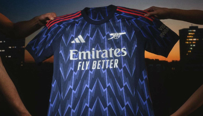 Camisa reserva Arsenal 2025/26 azul-marinho com listras vermelhas adidas e design inspirado no raio histórico dos Gunners.