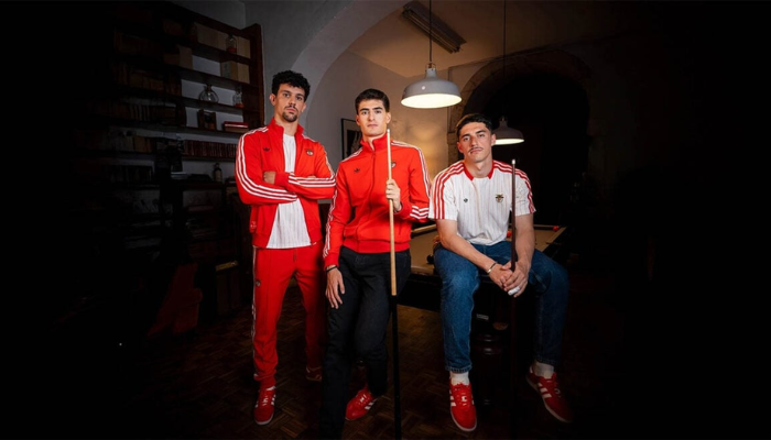 Camisa Icon Range Travel Benfica 2025 estilo retrô, riscas brancas, detalhes vermelhos, frase “Designed in Herzogenaurach” e escudo do Benfica bordado