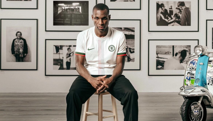 Camisa reserva Chelsea Nike 2025/26 branca com listra central laranja e preta.