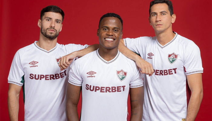 Camisa reserva Fluminense Umbro 2025-2026 branca com gola V verde e grená, laterais em verde e grená, gráficos minimalistas, detalhe “Flu” pixelado na nuca.