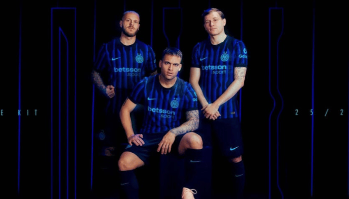 Camisa titular Inter de Milão 2025/26 com listras azul e preto, efeito óptico formando “INTER”, gola preta, escudo azul claro, logo Nike e patrocinadores também em azul claro
