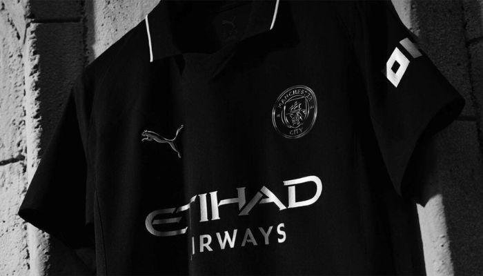 Camisa reserva do Manchester City 2025/26 preta Puma com detalhes prateados metálicos inspirada no uniforme de 1884.