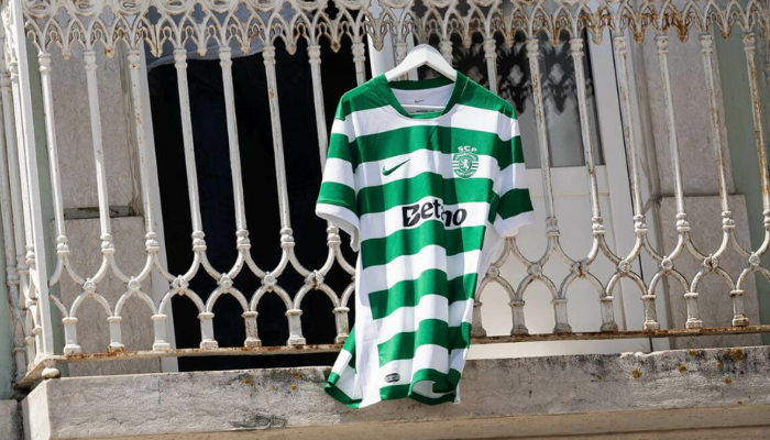 Camisa Titular Sporting CP Nike 2025-26 com listras horizontais verdes e brancas, gola verde, mangas listradas, escudo do Sporting no peito e logo da Nike em verde.