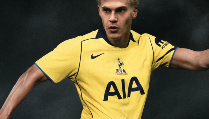 Terceira camisa Tottenham Nike 2025/26 versão torcedor, amarela com detalhes em azul marinho e escudo retrô centralizado.