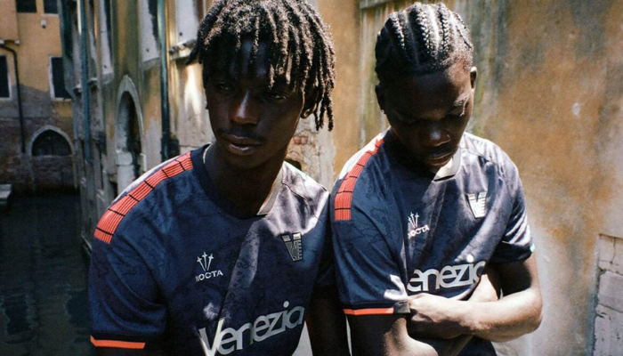 Camisa titular Venezia NOCTA 2025/26 versão torcedor em preto com detalhes prateados e faixas em verde e laranja.