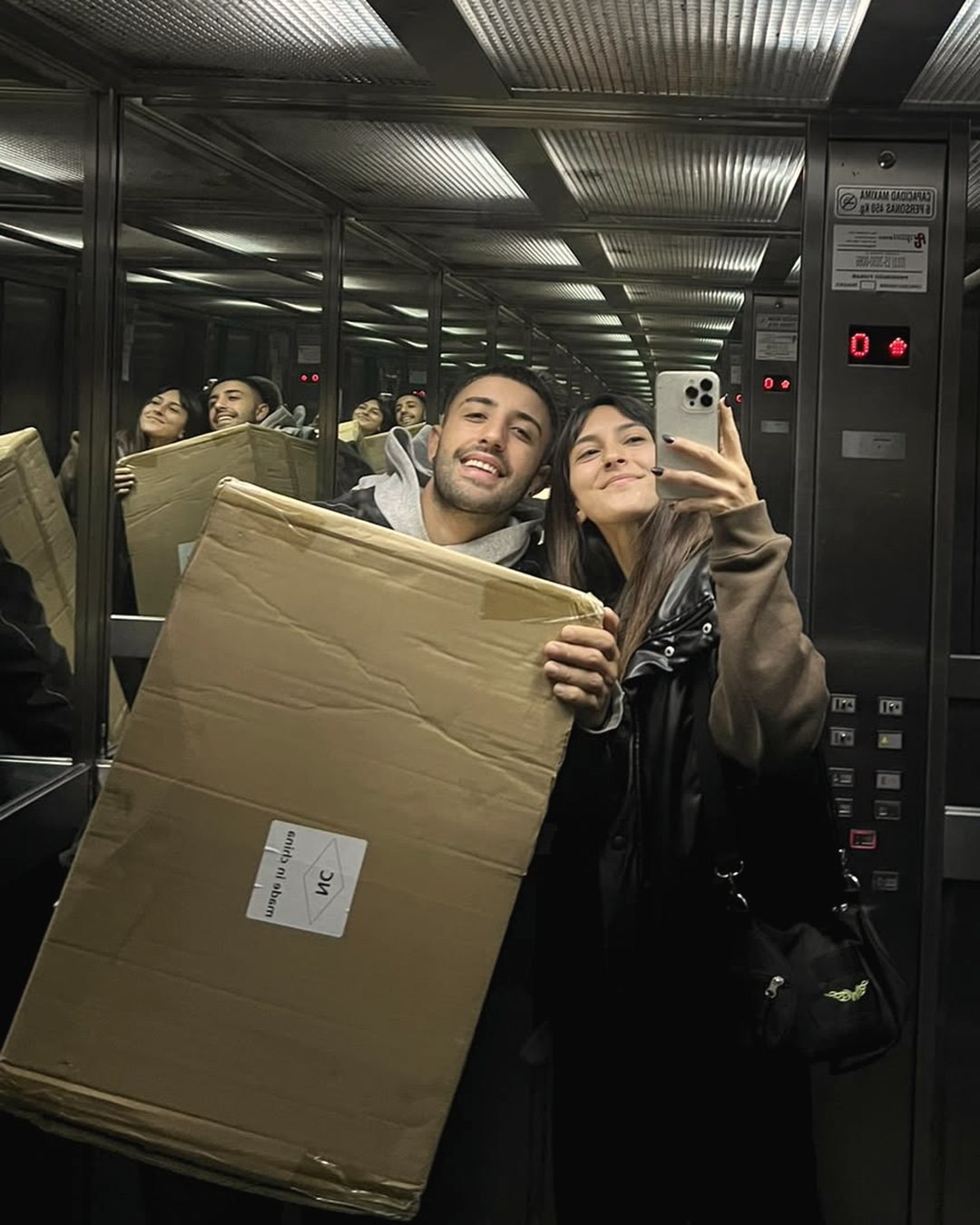 Belén y Hernán en el ascensor con una caja