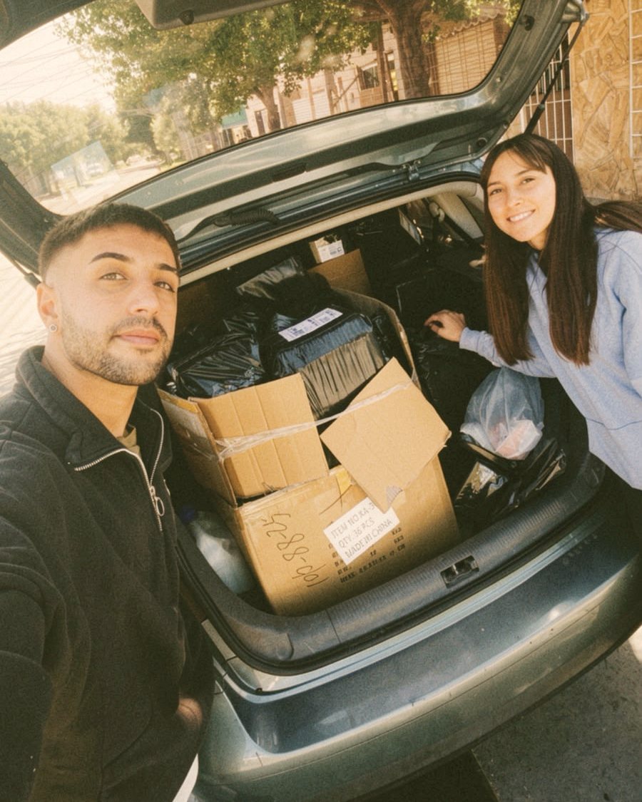 Belén y Hernán con el baúl del auto lleno de pedidos