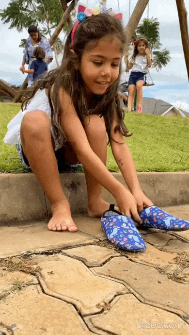 Criança calçando a sapatilha Acquatilha.