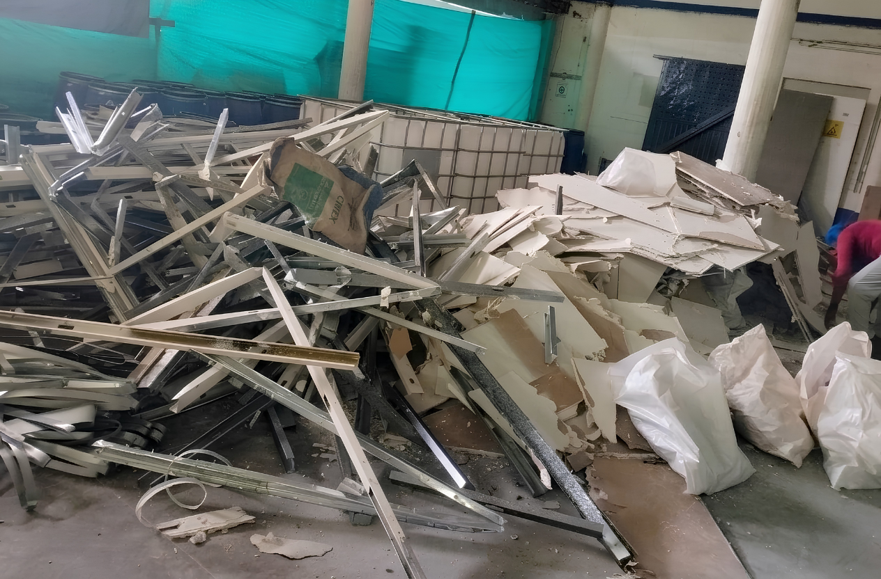 Acumulacion de perfiles metalicos, laminas de drywall y bultos de escombros para recoleccion en obra comercial en Guayabal Medellin