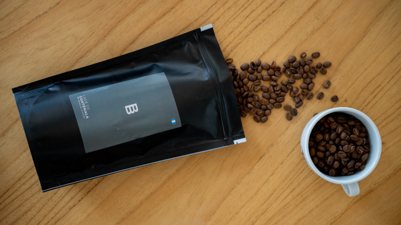 Paquete de café Bruno Brown con granos y taza