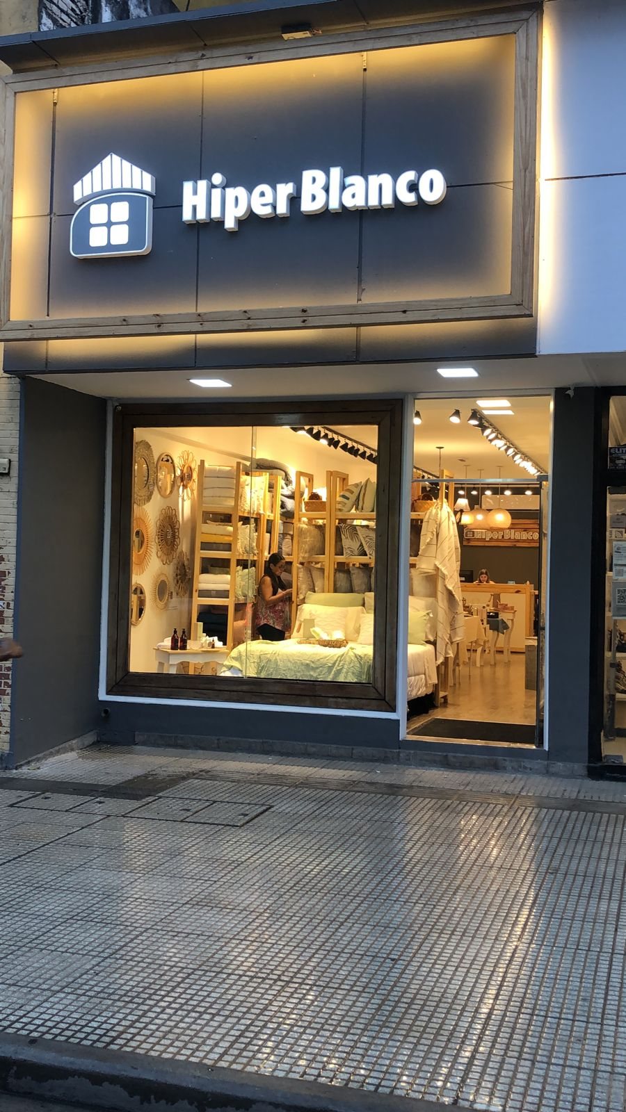 Vidriera de un local de Hiper Blanco con una cama exhibida