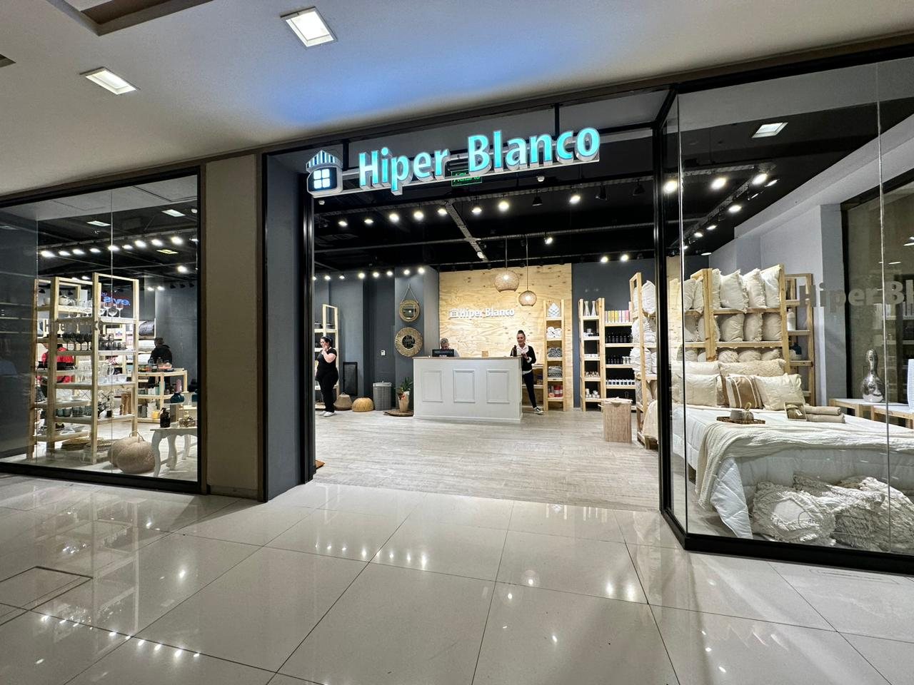 Local de Hiper Blanco en shopping, con el cartel iluminado y el mostrador de atención