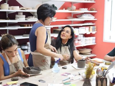 Simoni Nishimura orientando aluna durante oficina de cerâmica no ateliê Shoyu Crafts