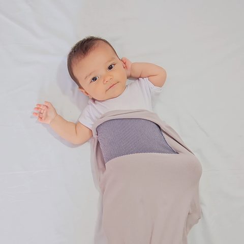Bebê deitado com o Pupa vestido até a barriga